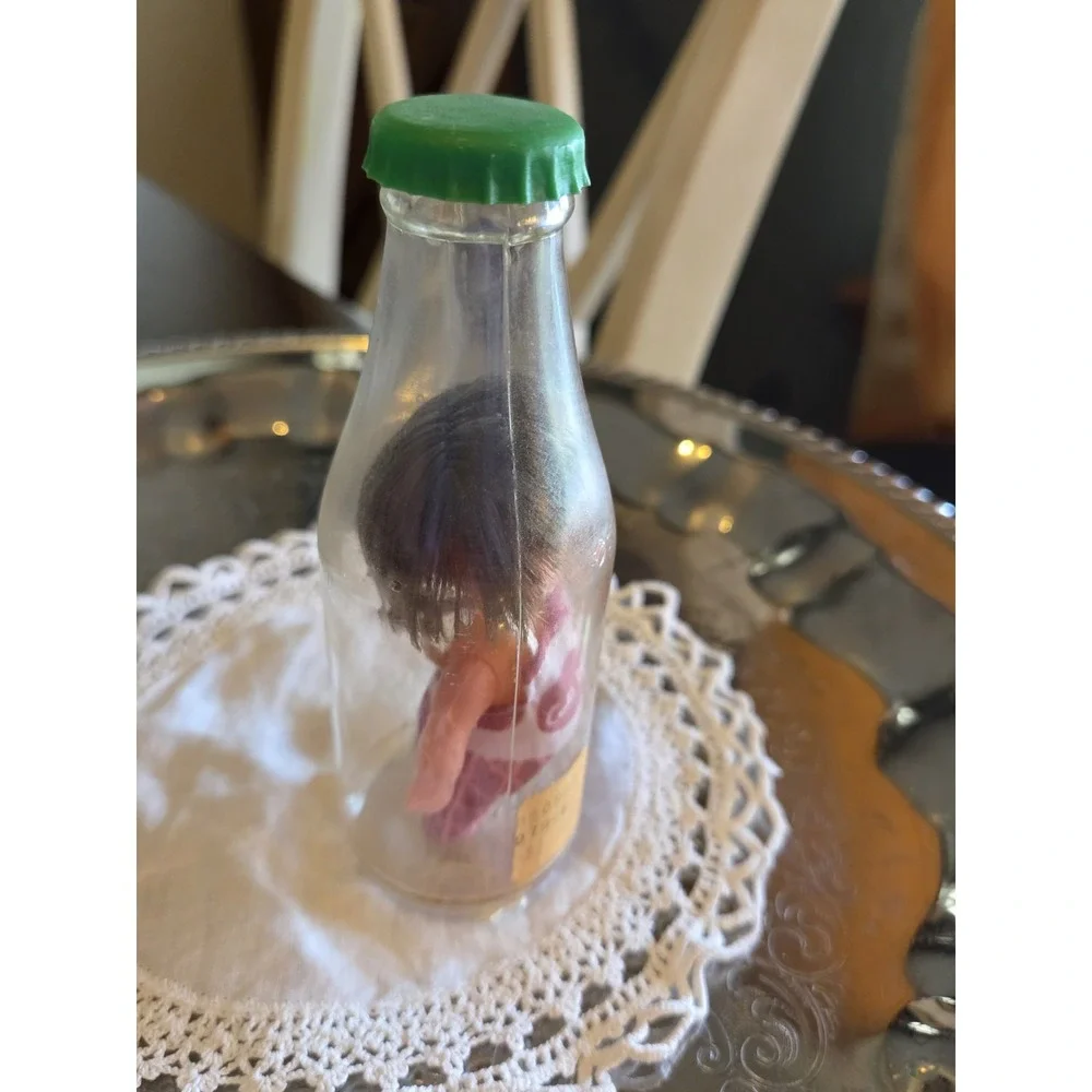 vintage 1960s Cola Kids doll is encased in a clear plastic bottle